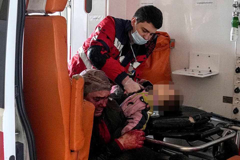<p>A paramedic performs CPR on a girl injured by shelling in a residential area. Her dad sits to the left. The girl did not survive</p>